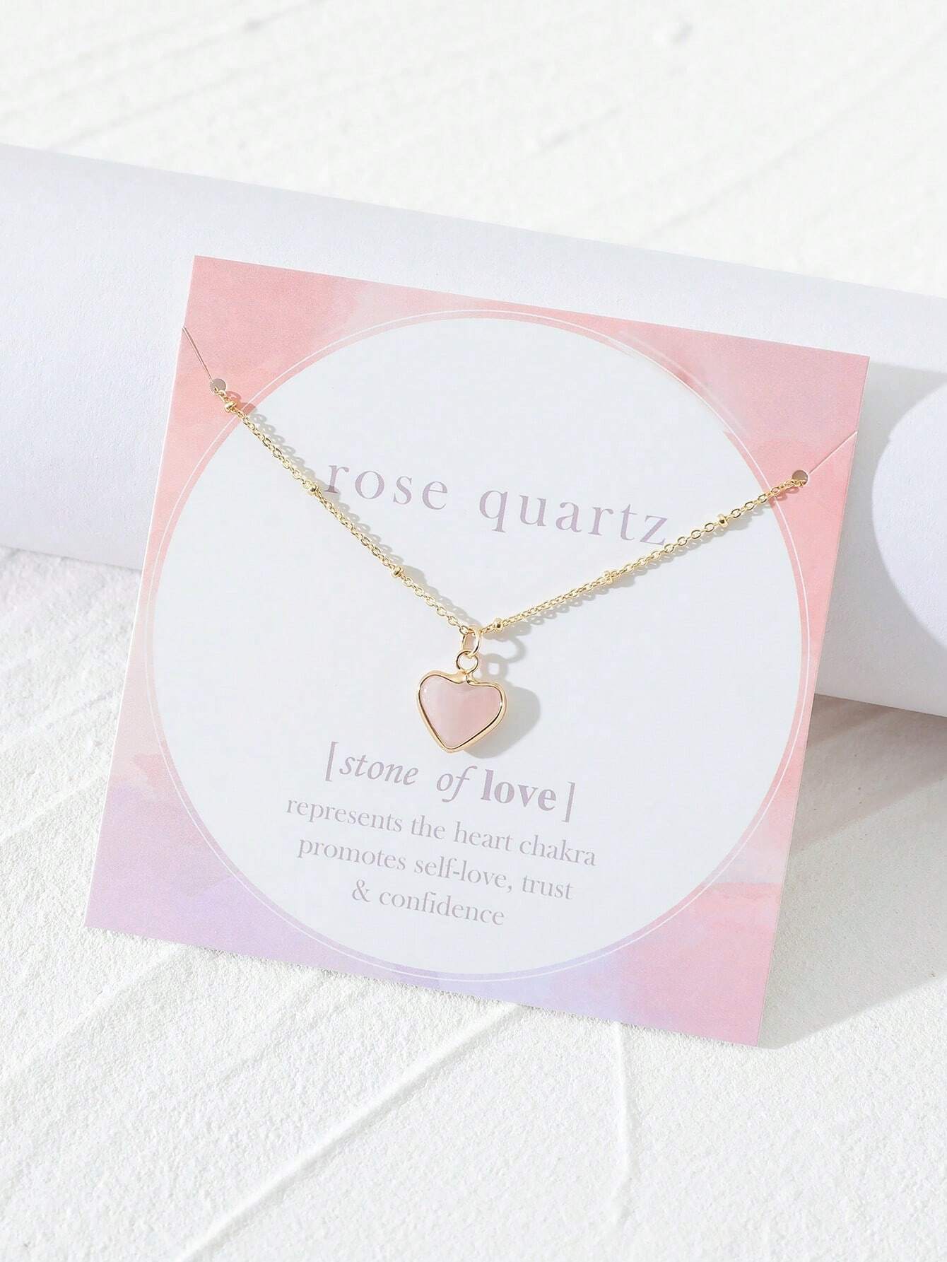 colgante de cuarzo rosa en forma de corazón sobre fondo blanco