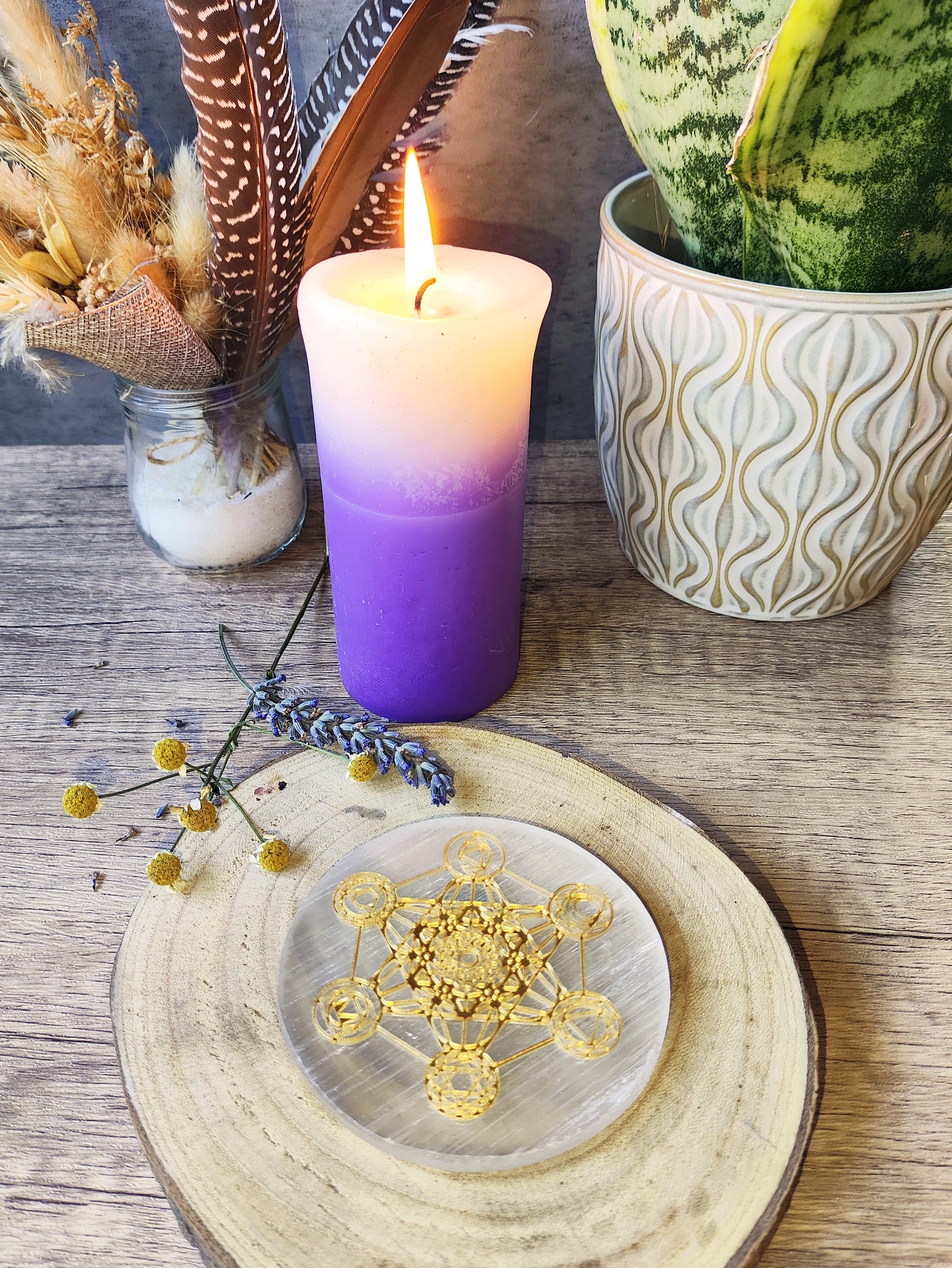 Placa de selenita blanca con diseño sagrado de Metatrón, presentada en altar con decoración mágica y luz de vela encendida.

