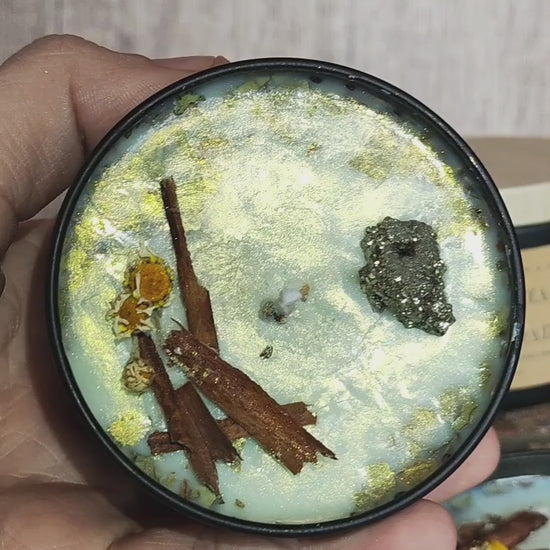 Vela ritualizada Abundancia y Prosperidad con pirita, brillo dorado y hierbas mágicas; movimiento para apreciar los detalles.