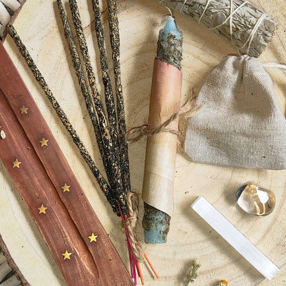 Conjunto esotérico de limpieza energética con vela blanca ritualizada, minerales y salvia, presentado como Pack Buena Energía.